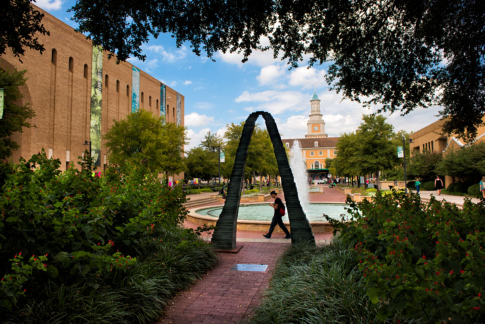 Student at the library mall next to arch