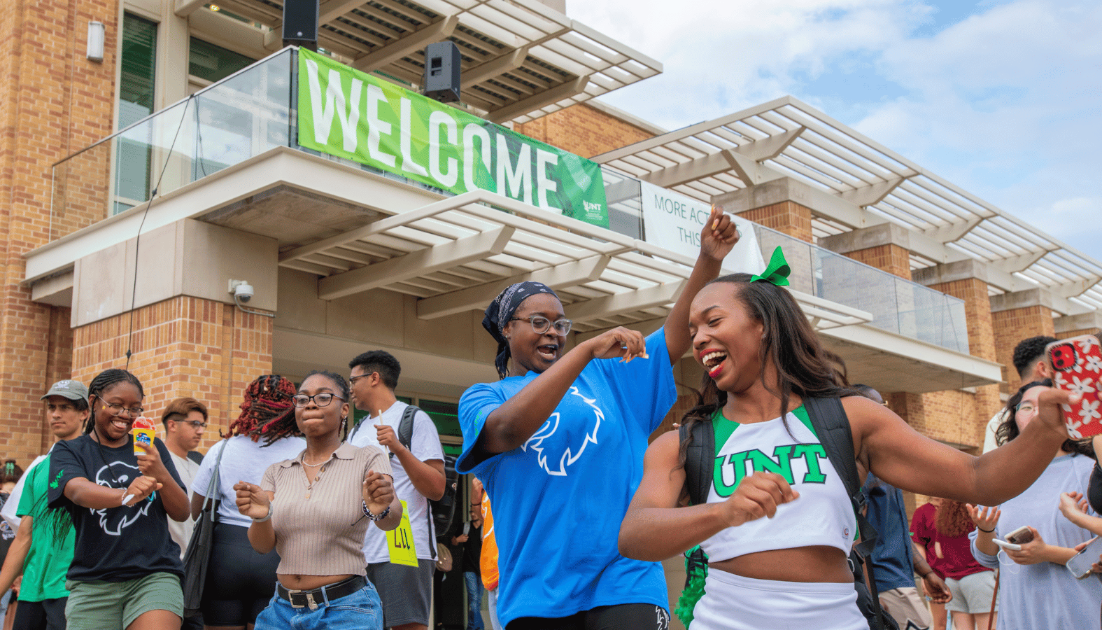 Students at dancing in front of union welcome sign