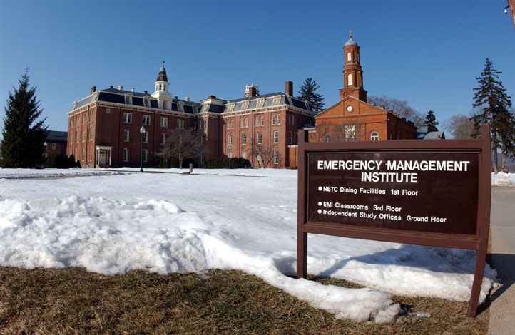 Picture of EMI Campus with Emergenct Mangement Institute sign in foreground and Buildings N and O in the background