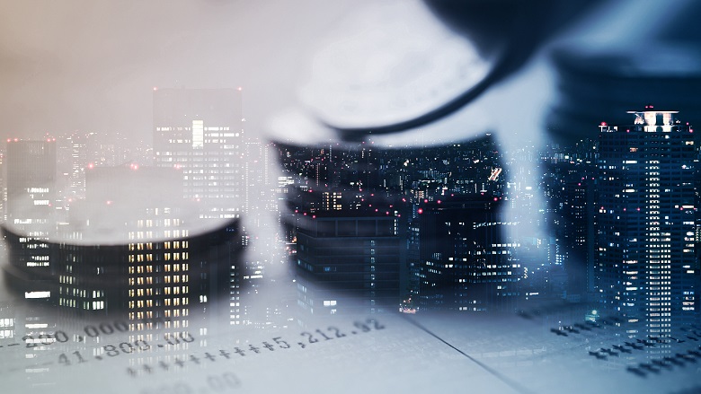 Double exposure of a city and rows of coins representing finance and banking