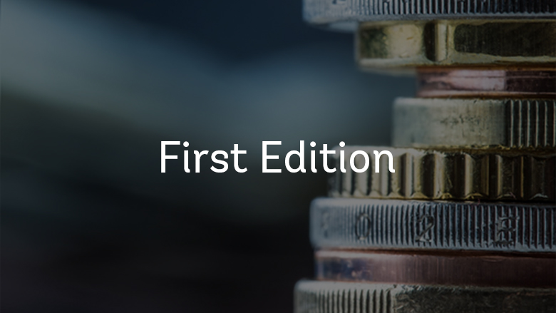 A stack of coins with a blurred dark navy background with First Edition text