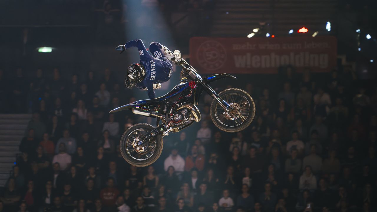 Ein Motorradfahrer, der bei einer Rampe einen Trick ausführt