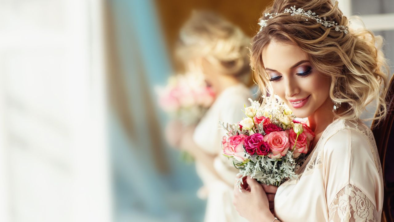 Eine Frau in einem weißen Kleid und einem Blumenstrauß in der Hand