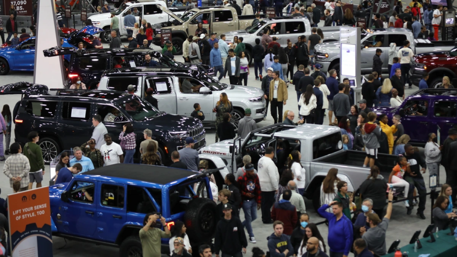 A floor crowded with people and cars at a past North American International Auto Show in Detroit.