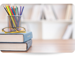 Textbook stack with eyeglasses and stationary on desk in Library. Education concept