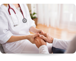 Unrecognizable health visitor and a senior man during home visit. A nurce holding hands of a man