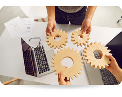 This picture shows teamwork. Hands of business people with gears and laptops in the table, top view