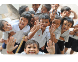 There is a group of happy students in primary school. They are all laughing and showing hands