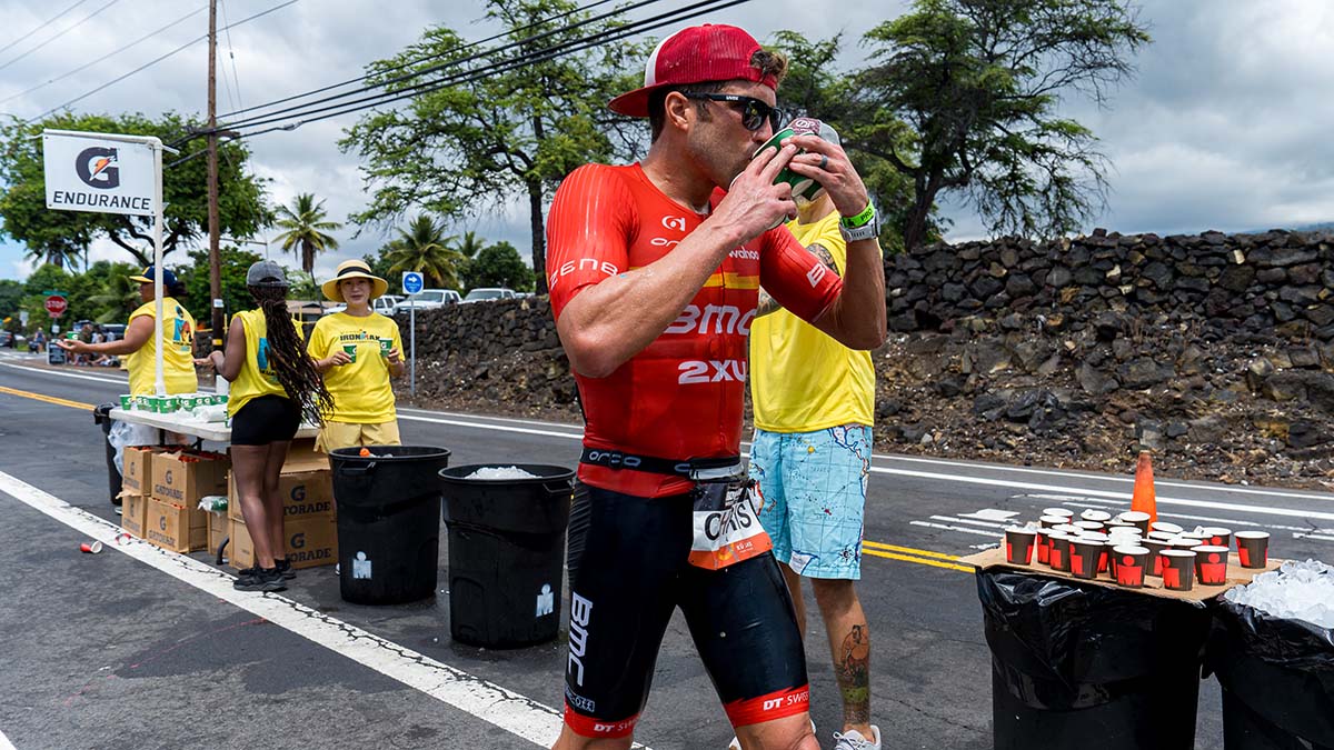 A Male Triathlete Drinks Water At An Aid Station During A Race In Kona Hawaii.