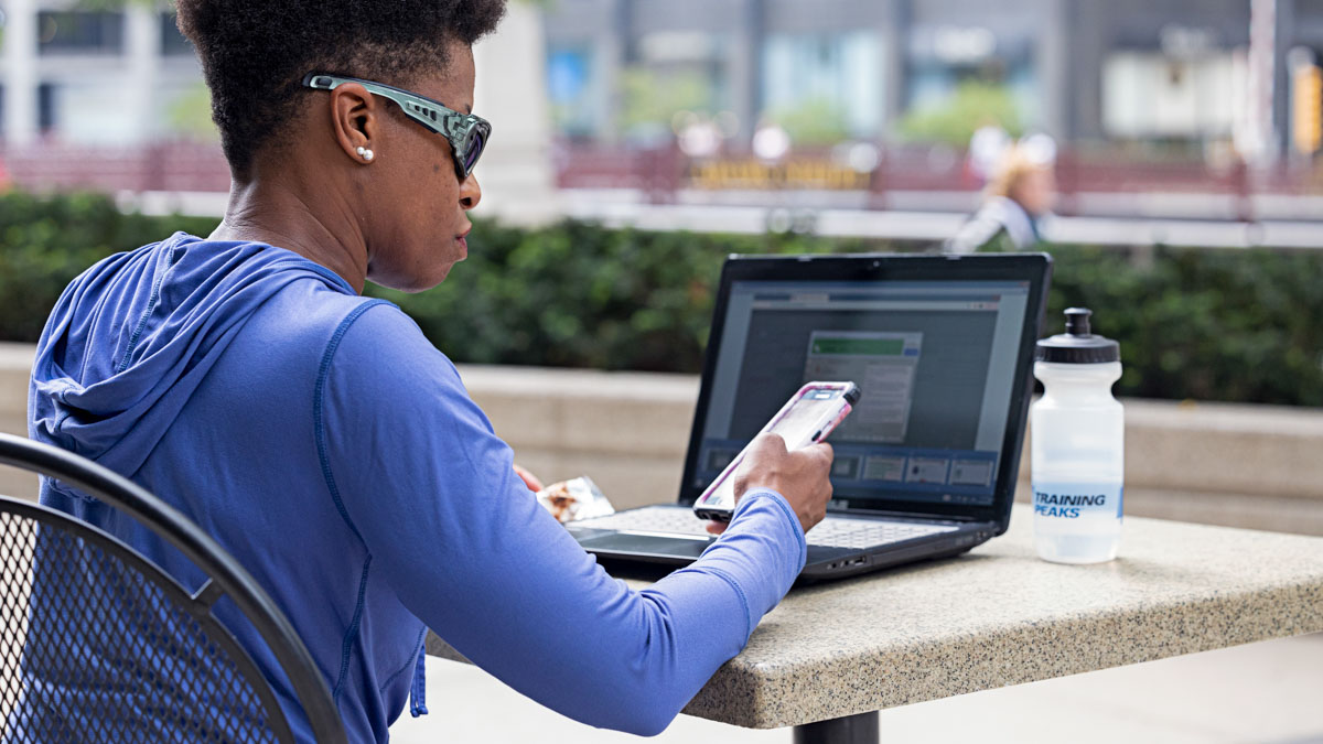 Triathlete Joy Miles Uses The Trainingpeaks App While Sitting On A Park Bench