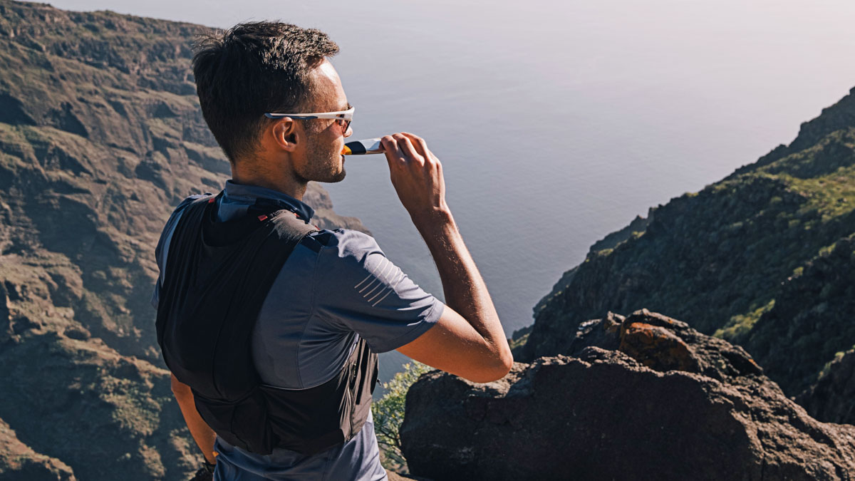 Portrait Of Young Man Drinking Energy Sports Nutrition Energy Gel While Sitting And Resting After Trail Running