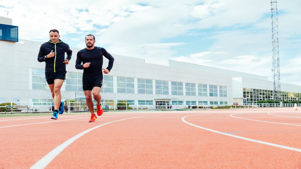 Group Of Young People Running On The Track Field