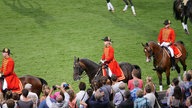 Ursula von der Leyen bei der Eröffnungsfeier der Reit-EM: Neben anderen Reitern reitet sie in roter Uniform und schwarzem Hut durch das Stadion.