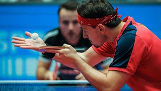 Timo Boll (Düsseldorf) schlägt gegen den Ochsenhausener Simon Gauzy auf.