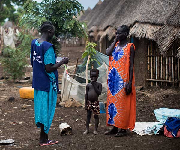 South Sudanese refugees supported by an Action Against Hunger member of staff to tackle food insecurity caused by conflict.