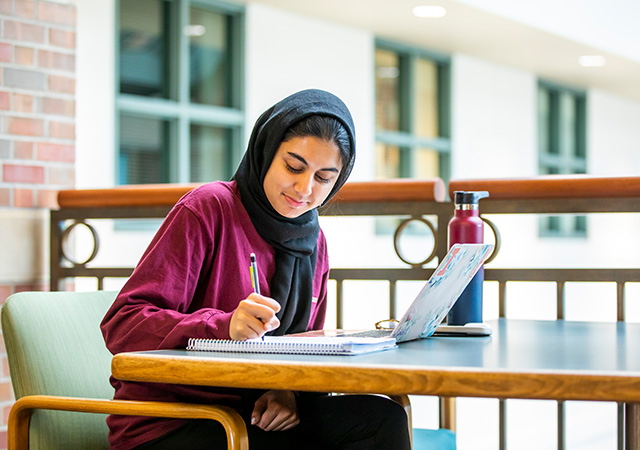 student writing in a notebook