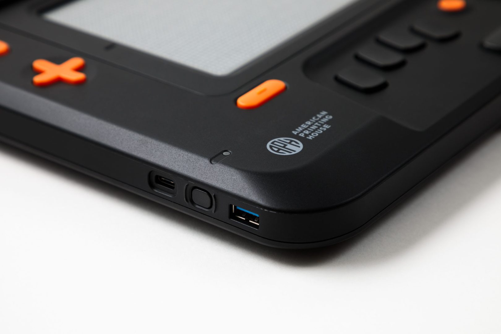 Close up of Monarch logo on the device just above the tactile display. There is a small indentation in the plastic that aligns with the motion sensor.