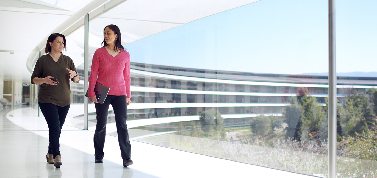 Two Apple employees walk through the hallways at Apple Park.