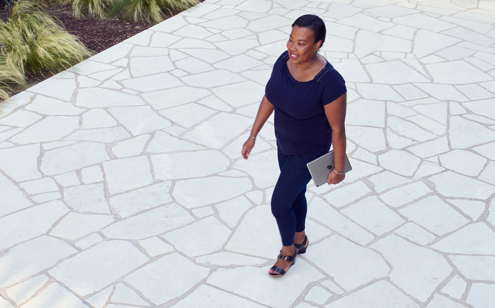 A female Apple Support Advisor is walking outside at the Apple campus.