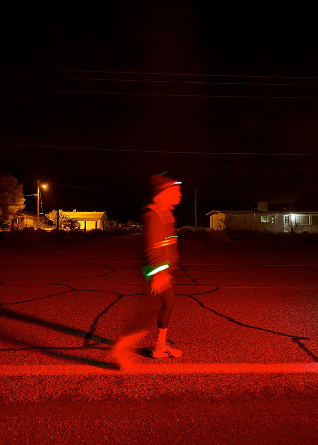 Un runner sulla strada di notte con indumenti riflettenti.