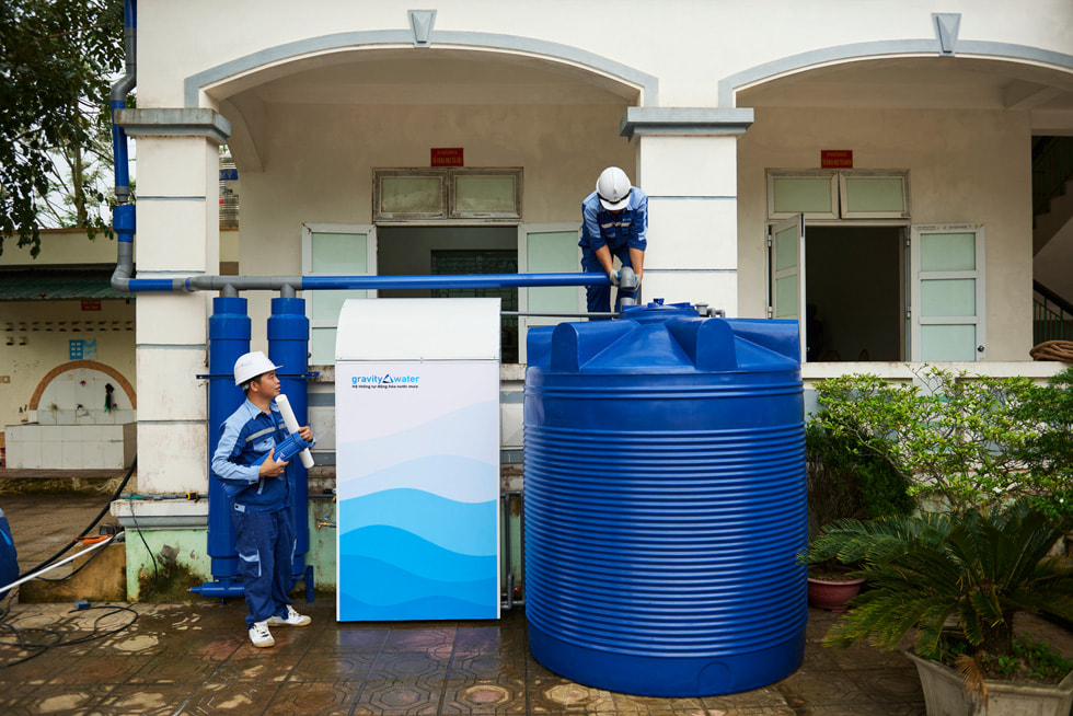 บุคคลหนึ่งกำลังตรวจสอบระบบของ Gravity Water ในขณะที่อีกคนหนึ่งคอยดูอยู่