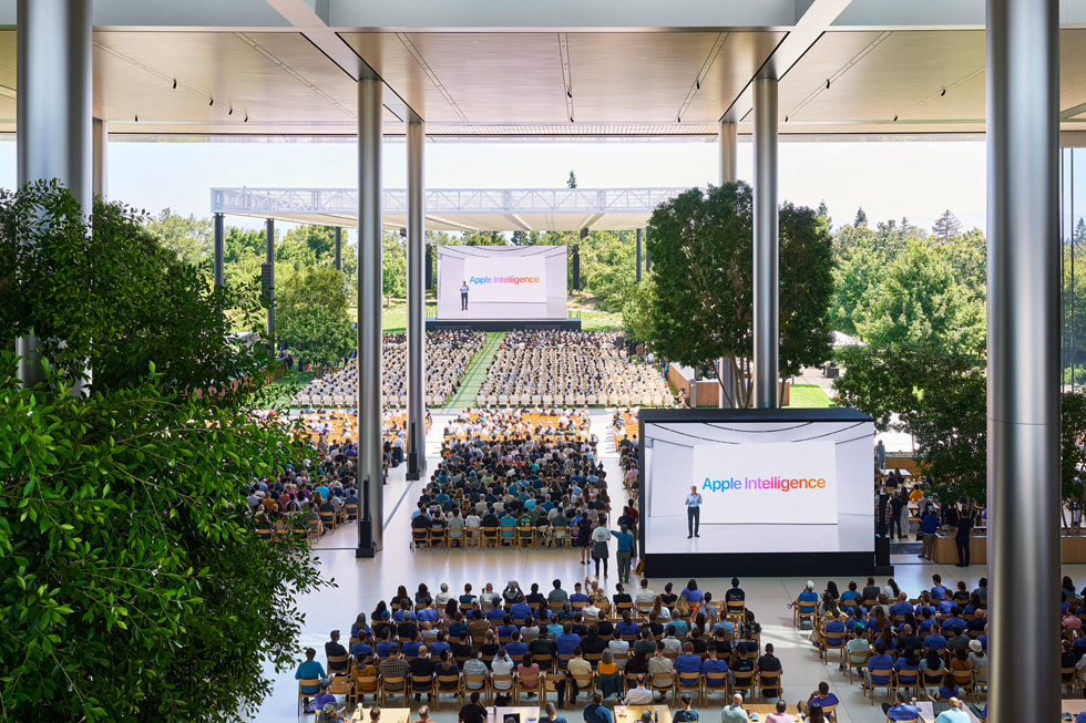 Apple ParkのCaffè Macsで大画面に映し出された基調講演のプレゼンテーションを観るデベロッパを上から撮影した写真。 