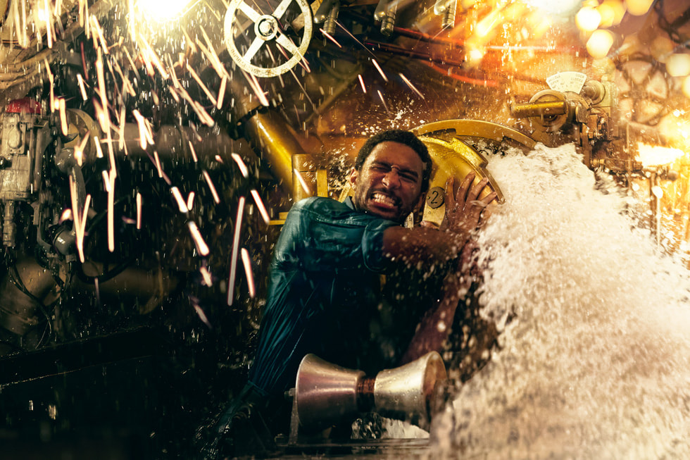 An action shot from “Submerged” shows the character James Dyson (played by Jordan Barton) battling a rush of water as sparks fly around him.