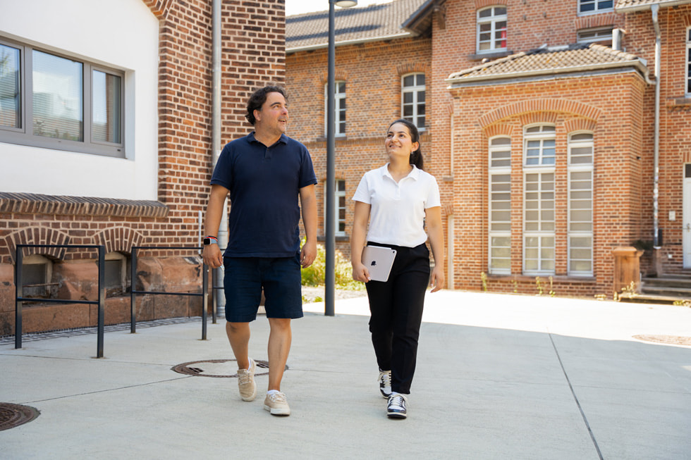 CodeDoor’s Karan Dehghani walks outdoors with participant Dunya Khalo.