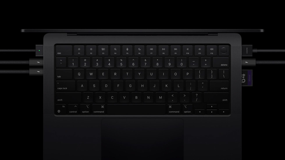 A close-up of the keyboard on MacBook Pro and its Thunderbolt 5 ports with plugged-in peripherals.