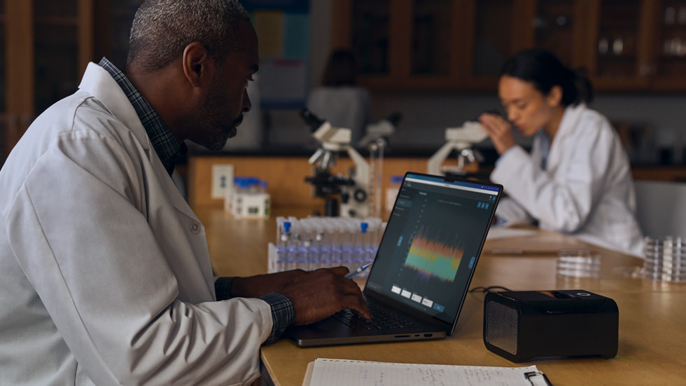 Two people work in a lab, with one using the new MacBook Pro.