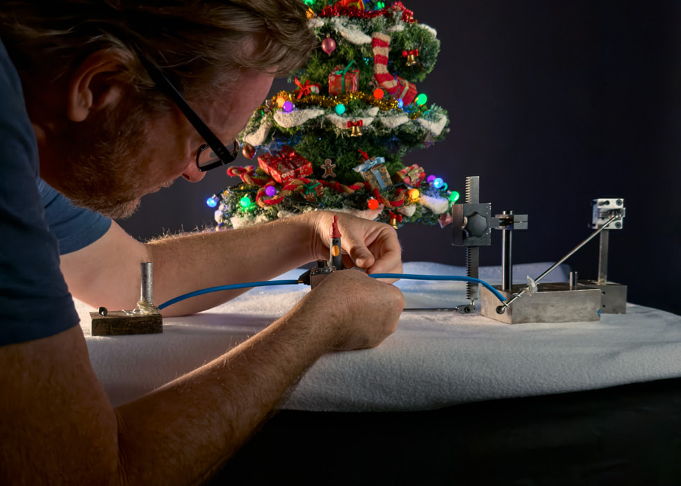 An animator adjusts the pose of a claymation Feathers McGraw in between shots.