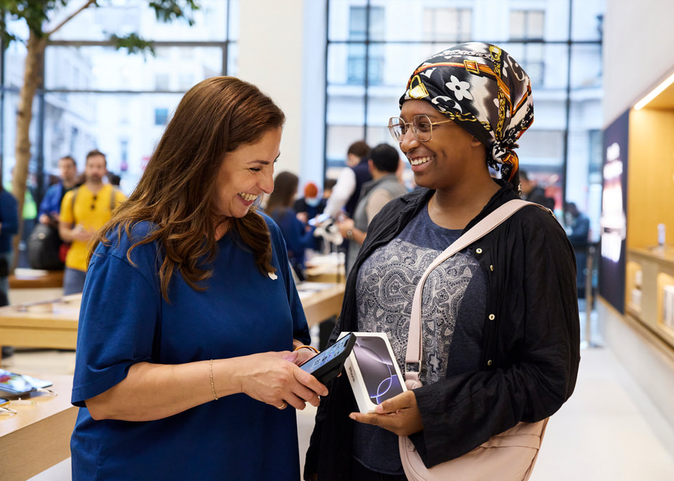 Inside Apple Regent Street in London, a team member helps a customer.