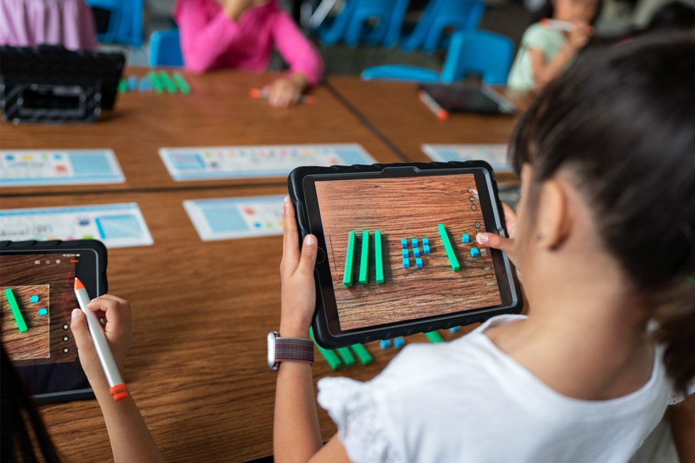 Una alumna usa un iPad en un salón de clases.