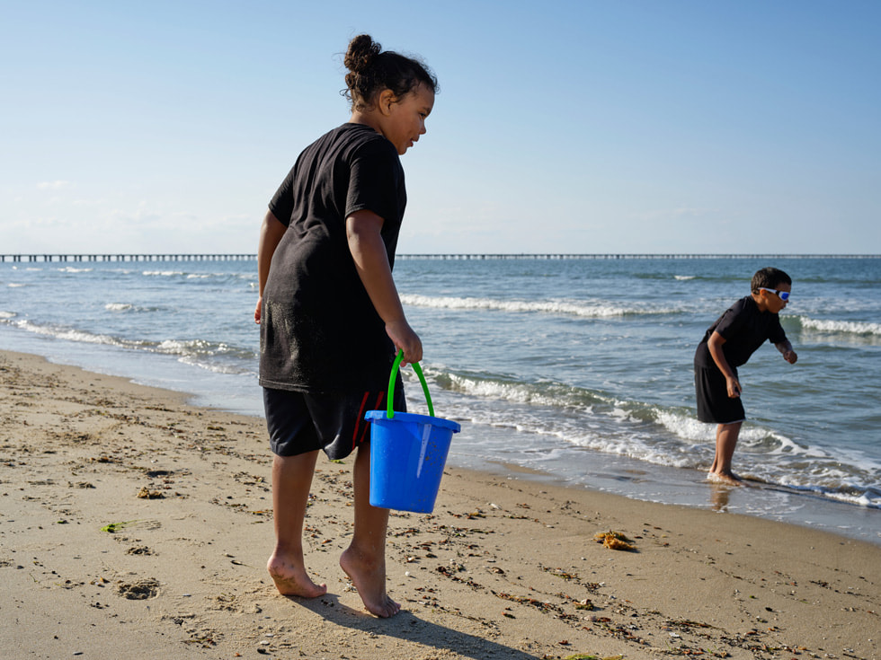 Jay (au premier plan) se tient sur le rivage avec son frère jumeau Nick.