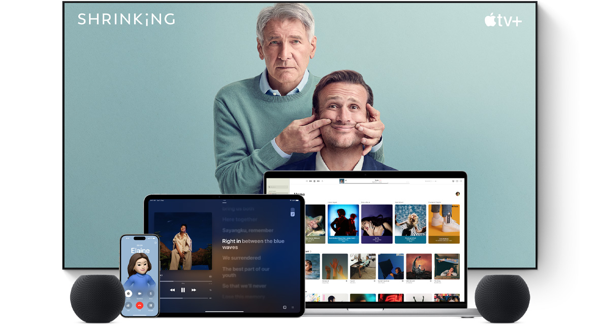 Large flat-screen television showing two male characters from the Apple TV+ series Shrinking. A MacBook Pro, an iPad, an iPhone and a Midnight HomePod mini are arranged in front.