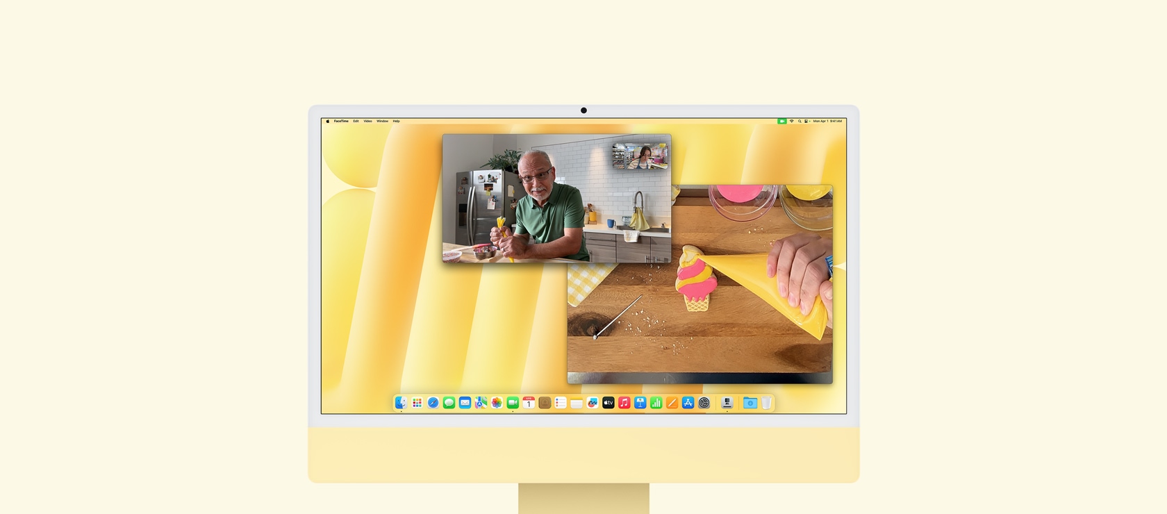 Desk View demo. Screen shows baker on video call with another person. One screen displays the baker and the man's face. The other screen displays the baker's hands icing a cookie