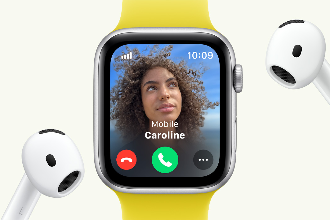 Apple Watch SE waarop een telefoontje binnenkomt, met ernaast een paar AirPods