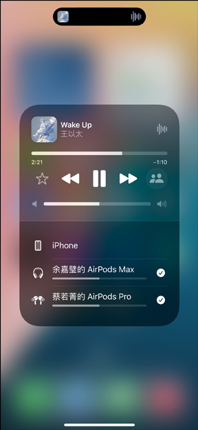 装有 AirPods Pro 的充电盒放在 iPhone 旁边。iPhone 与两副 AirPods 连接，可分别进行音量调节。