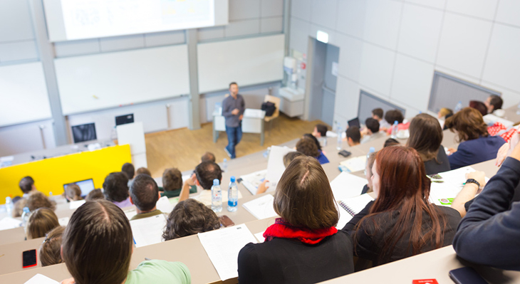 Studenten und Studentinnen sitzen in einem Lesesaal. 