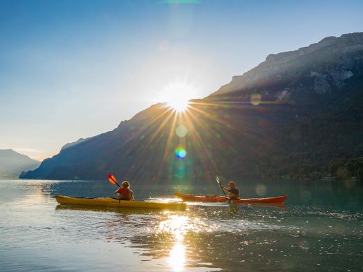 Zwei Männer mit Kajaks unterwegs auf dem Brienzersee während dem Sonnenaufgang