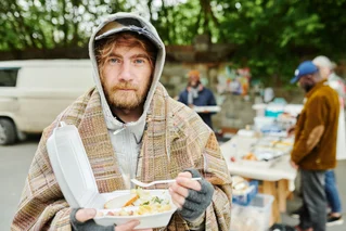 homeless man eating soup 