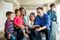 A family sitting on a couch looking at a tablet and having fun