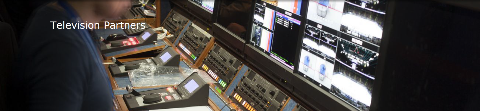 Text: Television Partners. Background image: A man in front of a television monitoring booth. 