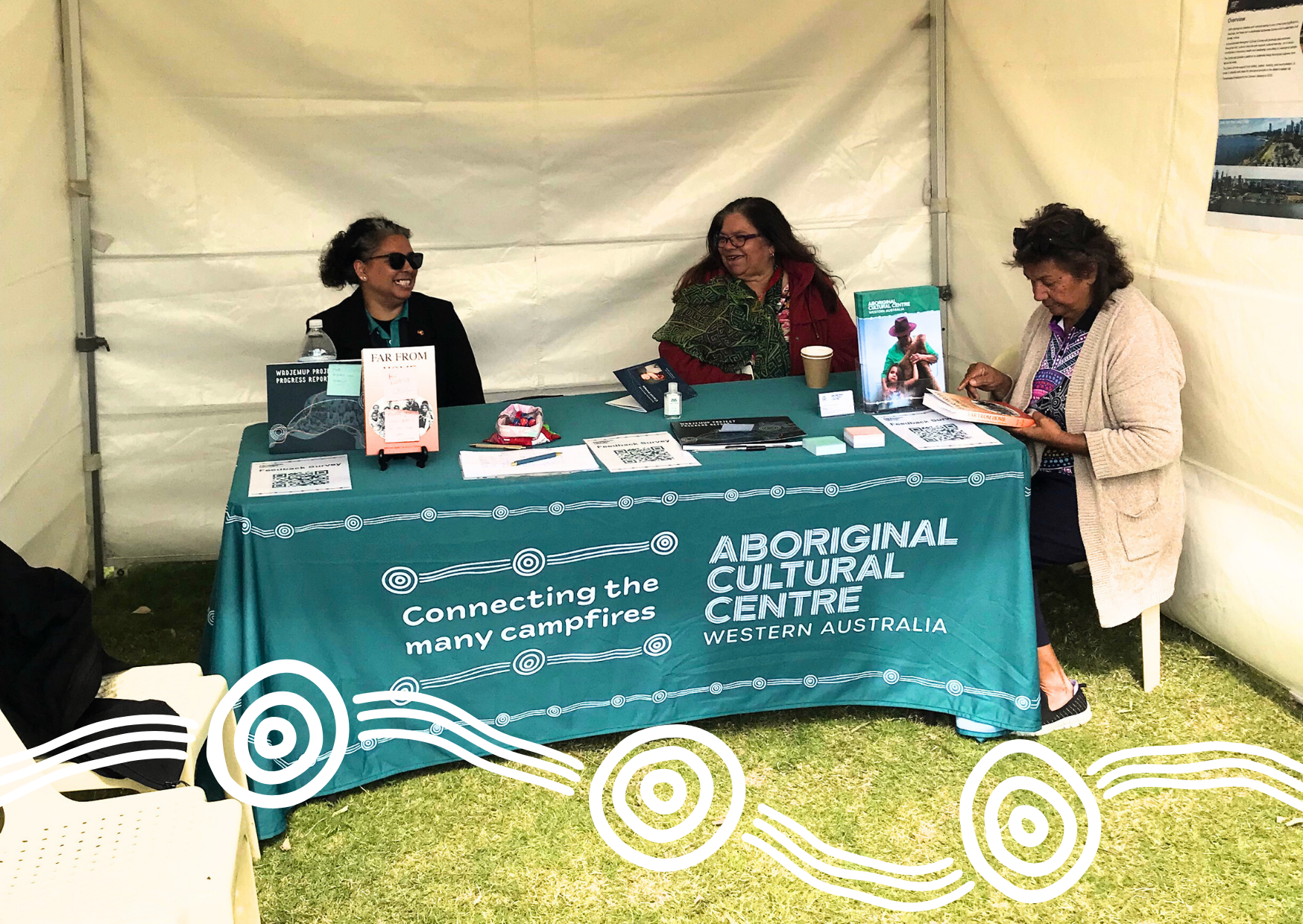 Three women sit together at the Aboriginal Cultural Centre stall at Yamatji on Country 2024