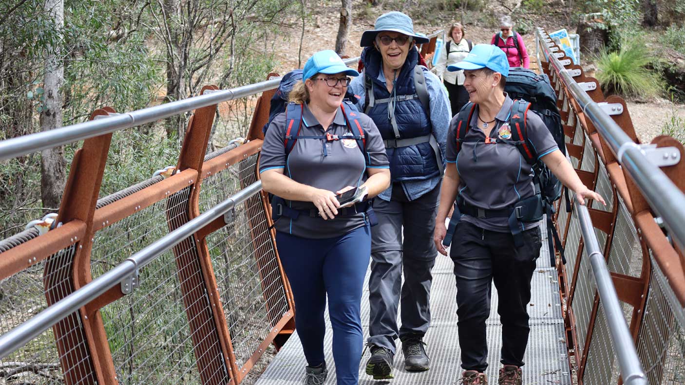 Hikers walking across a new bridge