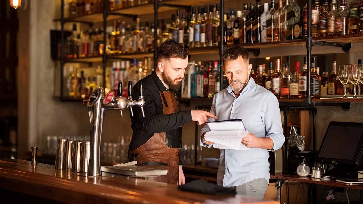 Shot of a bar manager and bartender checking the stock in the pub