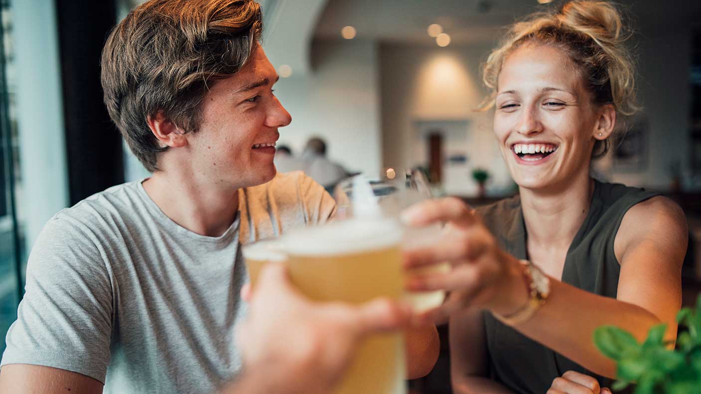 People toasting drinks at a table in a pub