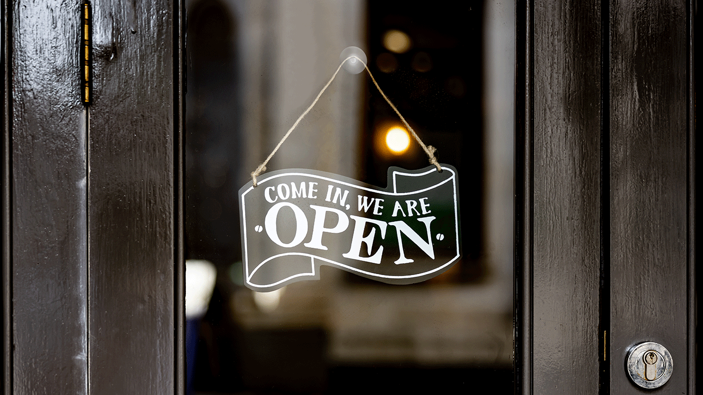 A close up of a pub front door with the sign "come in we are open'" on the door.