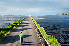 Image of engineer walking through solar panel plant - Just Transition