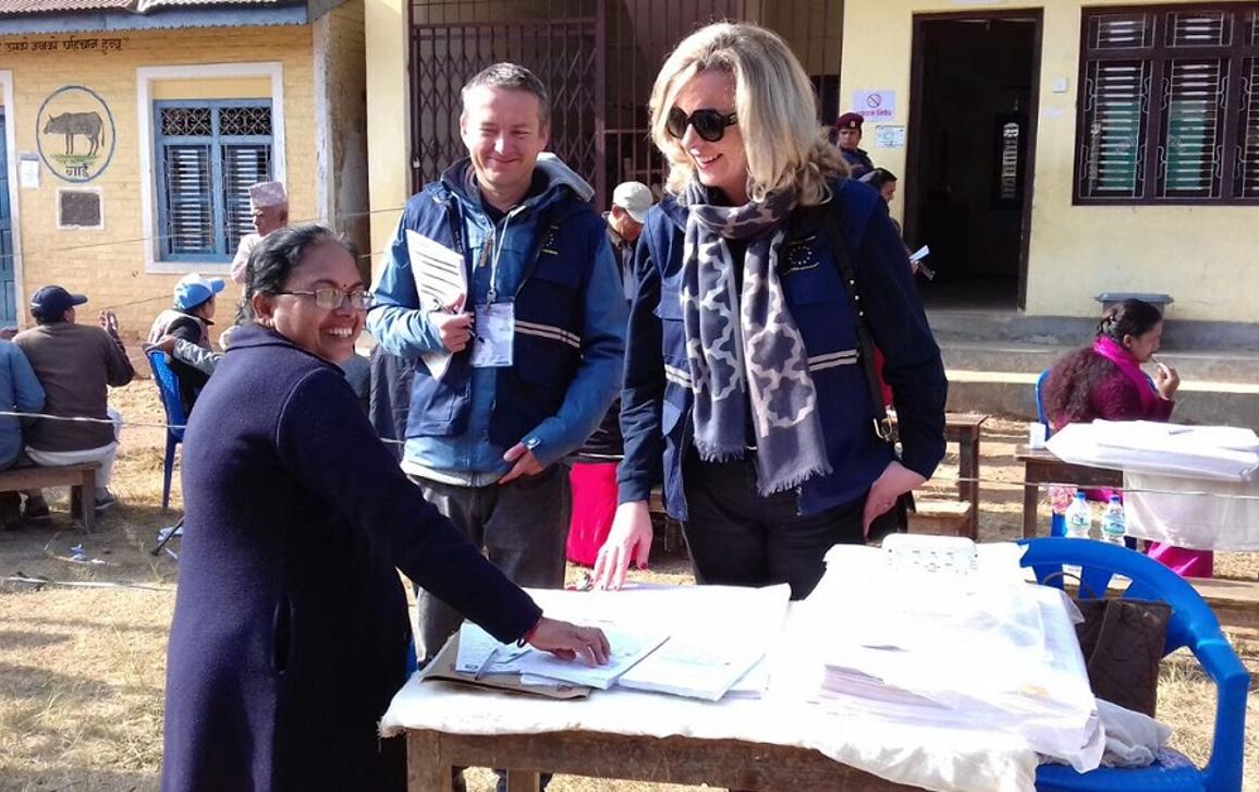 Member of the EU election observation mission talking to a person working at the polling station